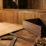 Ébéniste menuisier en atelier : panneau bois et quincaillerie pour meuble sur mesure